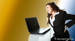 a person Pensacola bending over a computer holding her back due to pain